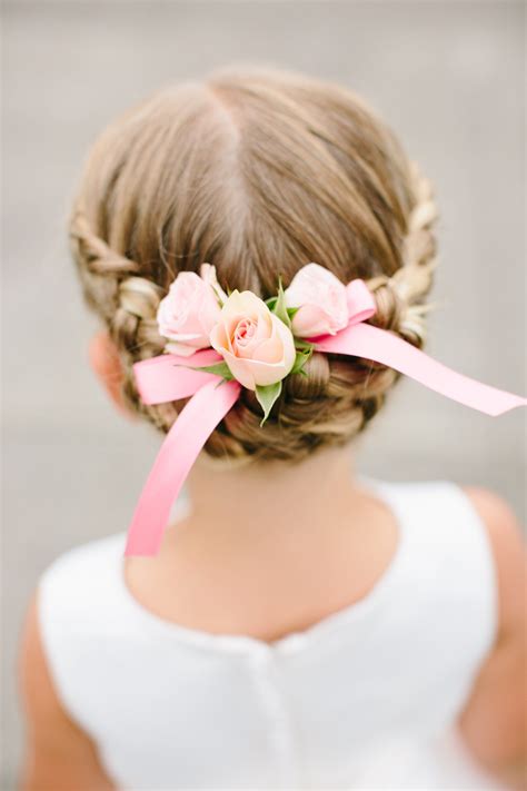the flower girls wore their hair in braided updos which they accented with pink roses and