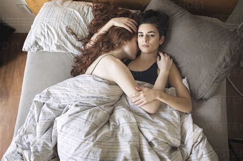 High Angle Portrait Of Lesbian With Girlfriend Relaxing On Bed At Home Stock Photo