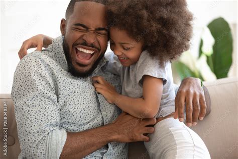Excited African American Dad Tickling Little Daughter Stock Photo