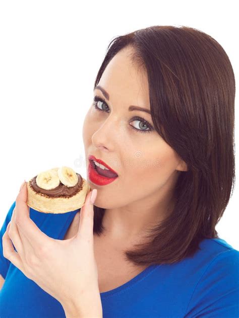 Young Woman Eating Crumpet With Chocolate Spread And Banana Stock Image
