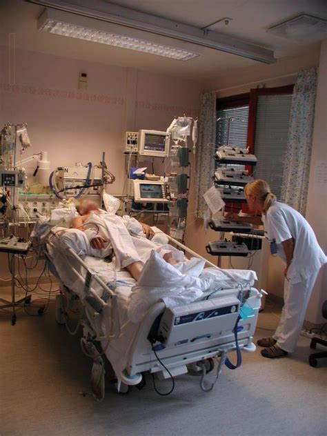 A Nurse Caring For A Patient In An Intensive Care Unit Download