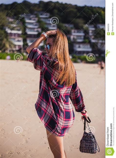 La Belle Femme Mince Dans La Chemise Les Shorts Et Les Lunettes De Soleil De Mode Marchent Sur