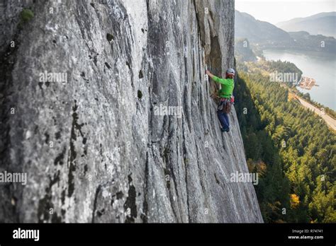 Young Female Rock Climber Climbing Up Rock Face Elevated View The