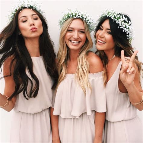 Three Beautiful Women Standing Next To Each Other With Flowers In Their