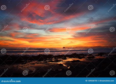 Colorful Sunset Over The Ocean With A Pier On The Horizon Stock Image