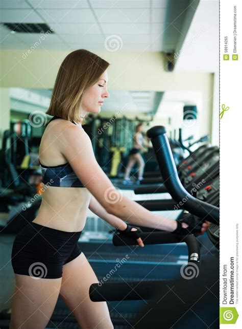 Pretty Girl Working In Treadmill At The Gym And Smiling Stock Image