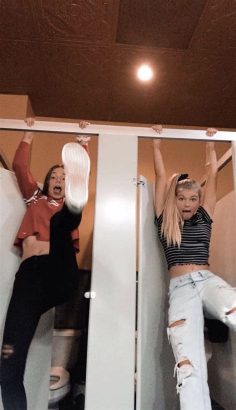 two women are hanging upside down on the bathroom wall and one woman is holding up her hair