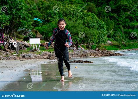 Cute Asian Girl Wearing A Black Swimsuit Running On The Beach Happily