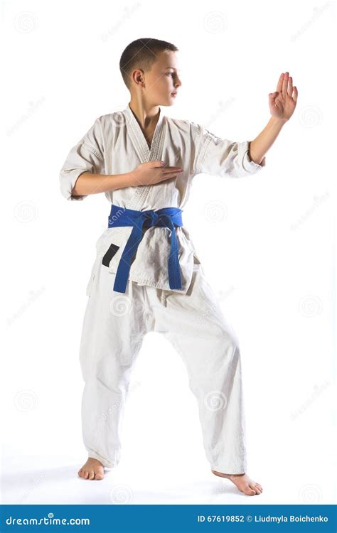 Muchacho Del Karate En Kimono Que Lucha En Un Fondo Blanco Foto De