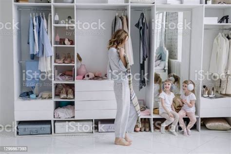 Young Woman Chooses A Dress In Her Modern Dressing Room Mom Shows Her