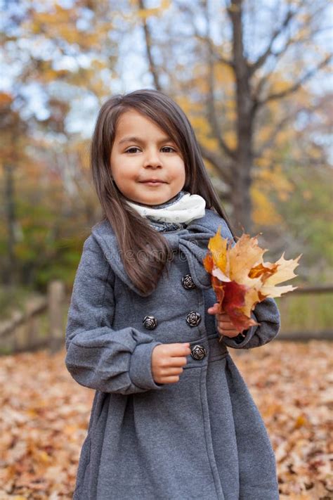 Little Pretty Girl With Autumn Leaves In An Autumn Park Stock Photo
