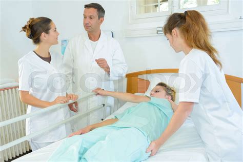 Nurse Rolling Patient Over In Hospital Bed Stock Image Colourbox