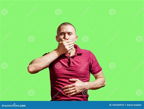 Man Put His Hand Over His Mouth Against The Green Background Stock