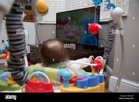 Baby In Jumperoo Watching Television Stock Photo Alamy