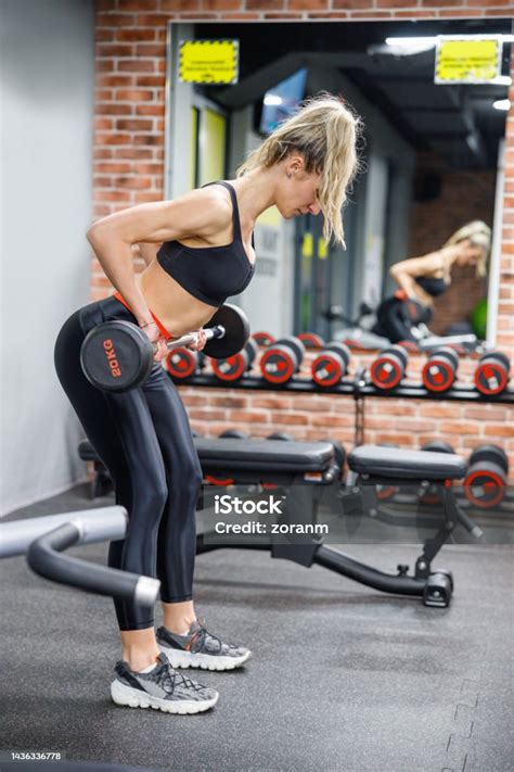 Strong Woman Bending Over And Lifting Barbell In The Gym Stock Photo