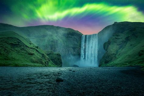 Green Aurora Light Behind Famous Skogafoss Waterfall Stock Image