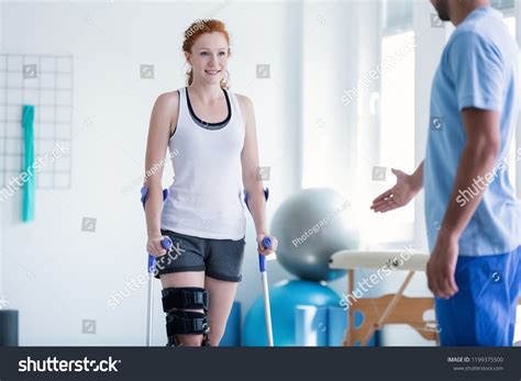 Woman Walking Crutches During Physiotherapy Stock Photo 1199375500