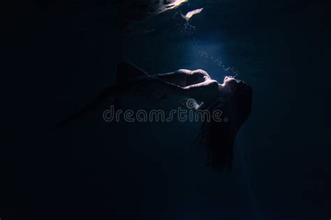 Underwater Shoot Of Beautiful Woman Swimming And Relaxing In Water In Sunbeams Stock Image