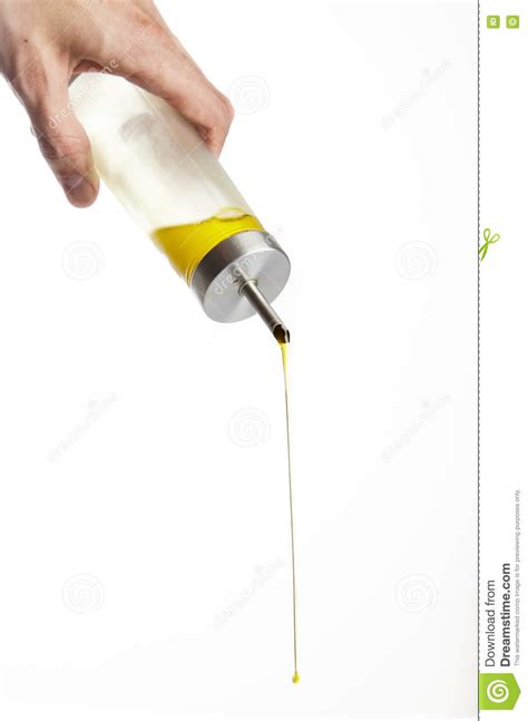 Hand Pouring Olive Oil From Glass Bottle On White Background Stock