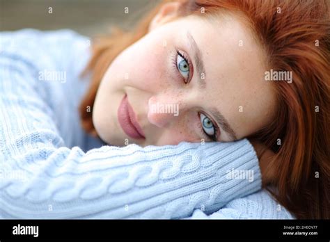 Portrait Of A Beauty Woman With Blue Eyes And Redhead Looking At Camera