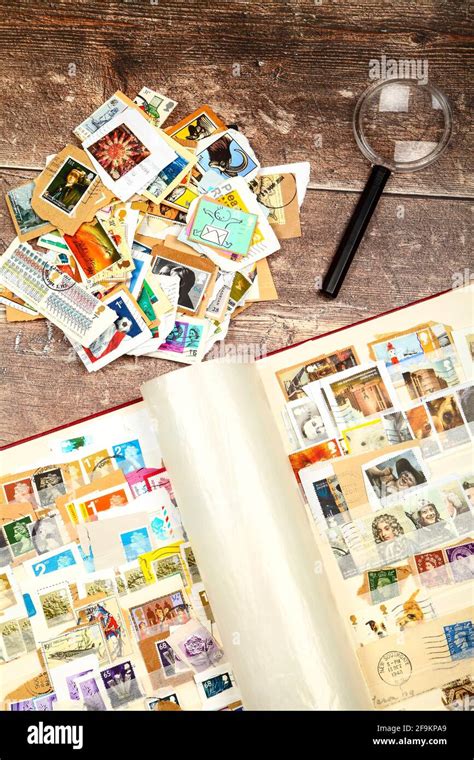 Stamp Album Full Of Used British Postage Stamps Laid On A Rustic Wooden