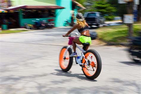 A Beautiful Slender Darkskinned Woman Riding A Bicycle Motion Blur