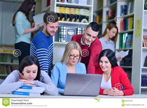 Group Of Students Working Together In Library With Teacher Stock Photo