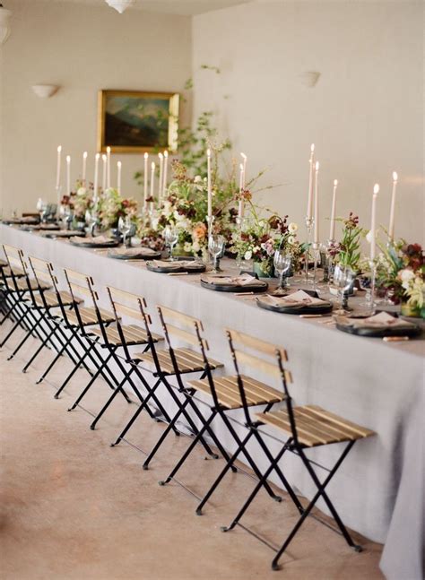 a long table is set with many chairs and place settings for the guests