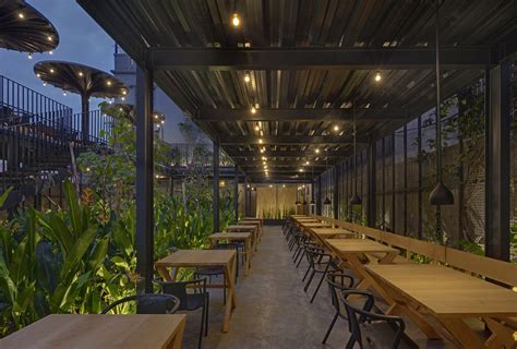 An Outdoor Dining Area With Tables And Chairs Lights Hanging From The