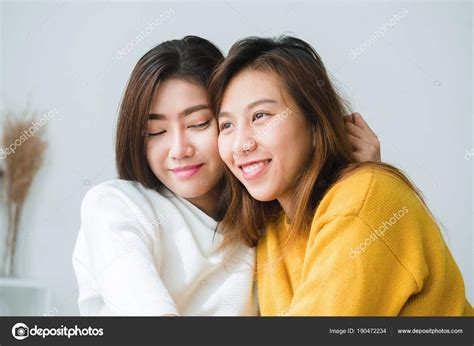 Dos hermosas mujeres asiáticas vestidas de forma casual abrazándose entre sí Foto de stock