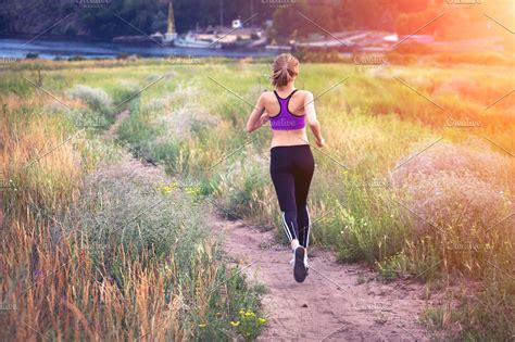 Young Woman Running At Sunset Stock Photo Containing Fitness And Woman