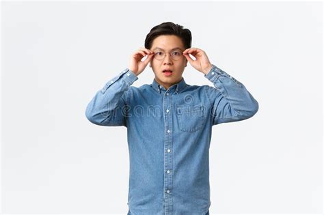Shocked And Impressed Asian Man Put On Glasses To See Something Looking Startled And Amazed
