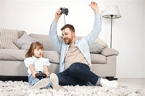 Girl With Down Syndrome And Her Father Sitting On A Floor And Playing