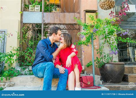 Beautiful Young Kissing Couple Sitting On The Stairs On Mediterranean