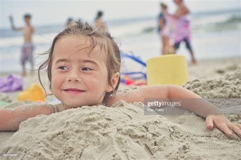Girl Buried In The Sand At The Beach High Res Stock Photo Getty Images