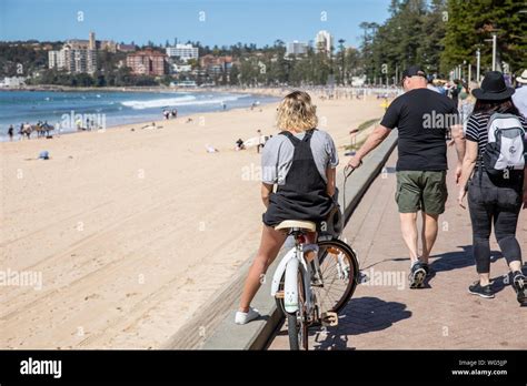 Teenage Girl Sits Astride Her Bicycle Relaxing Beside Manly Beach In