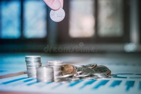 Handles Coins Placed On A Pile Of Money On The Table With Light Sunset