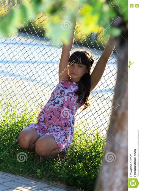 Красивый девочка подросток в розовом платье с длинными волосами в зеленом парке лета Стоковое