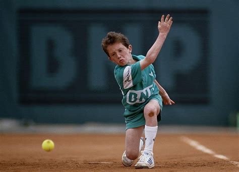 A Ballboy Passes Down A Tennis Ball Along The Court At The French Open