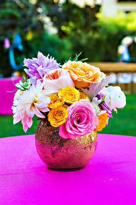 A flower arrangement is an artistic arrangement of flowers and apart from special occasions, one can also bring these floral arrangements to their living room, office table, or study table on any regular day. Colorful Flower Arrangement, Gold Vase