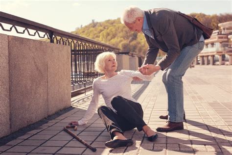 Polite Elderly Man Helping A Woman To Get Up Stock Image Image Of