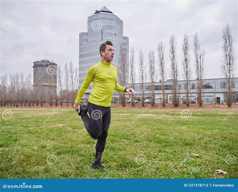 Man Running In The Parc In Winter With City Background Stock Photo
