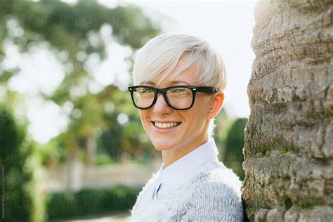 Blonde Woman Wearing Rimmed Glasses Standing On The Park By Stocksy