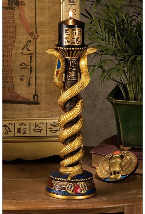 A Gold And Black Candle Holder With A Snake On The Top Is Sitting On A