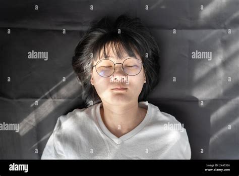 Cute Short Hair Glasses Asian Woman Laid On Black Wrinkled Cloth