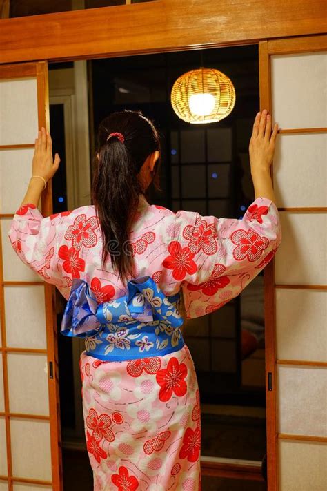 The Back Side Of A Woman In Traditional Japanese Garment Looking Out