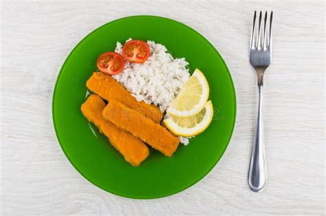 Fried Fish Sticks With Rice Tomatoes Lemon In Plate Fork Stock Image