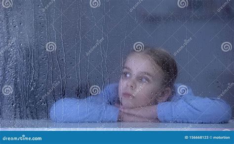 Lonely Girl Looking Through Rainy Window Lack Of Parental Love And Care