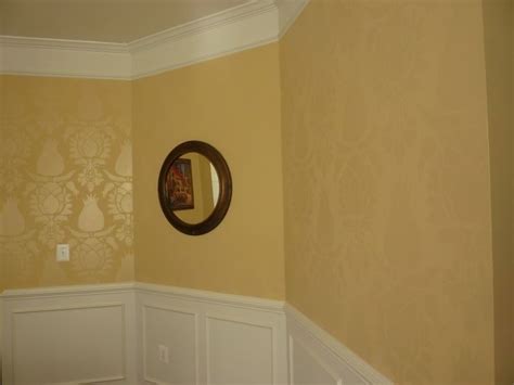 An Empty Room With A Mirror On The Wall And White Wainscote Trim