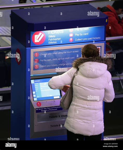 A Commuter Using A Ticket Machine At Kings Cross Station In London On